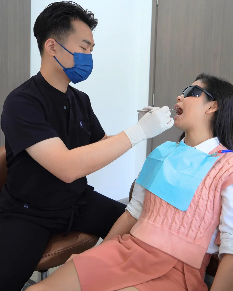Dentist examining a woman's mouth with a mirror