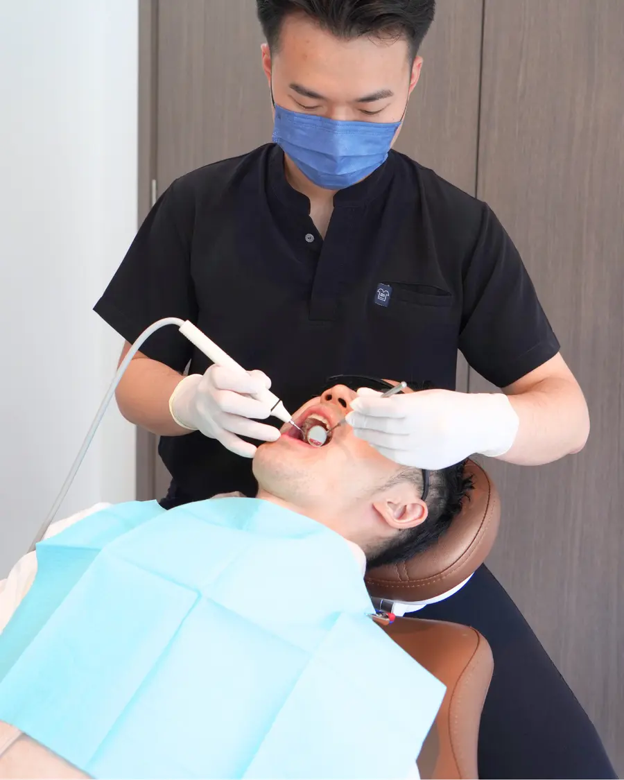 Dentist using an intraoral camera at the dental chair
