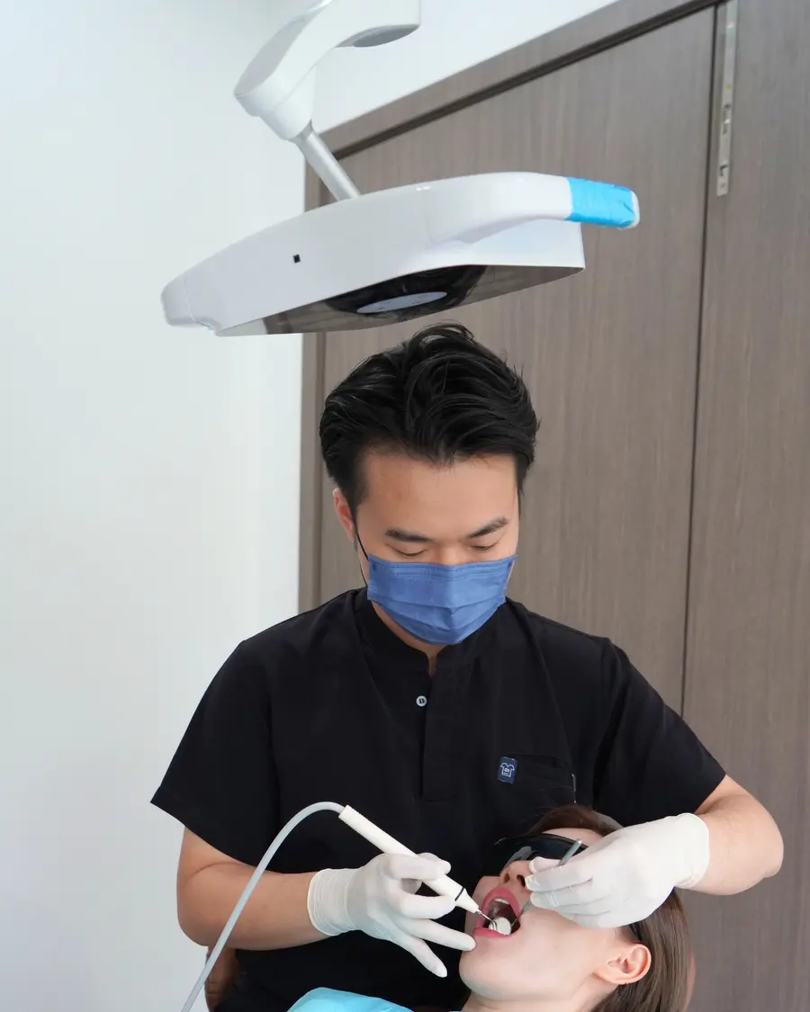 Dentist working under the overhead light at the dental chair