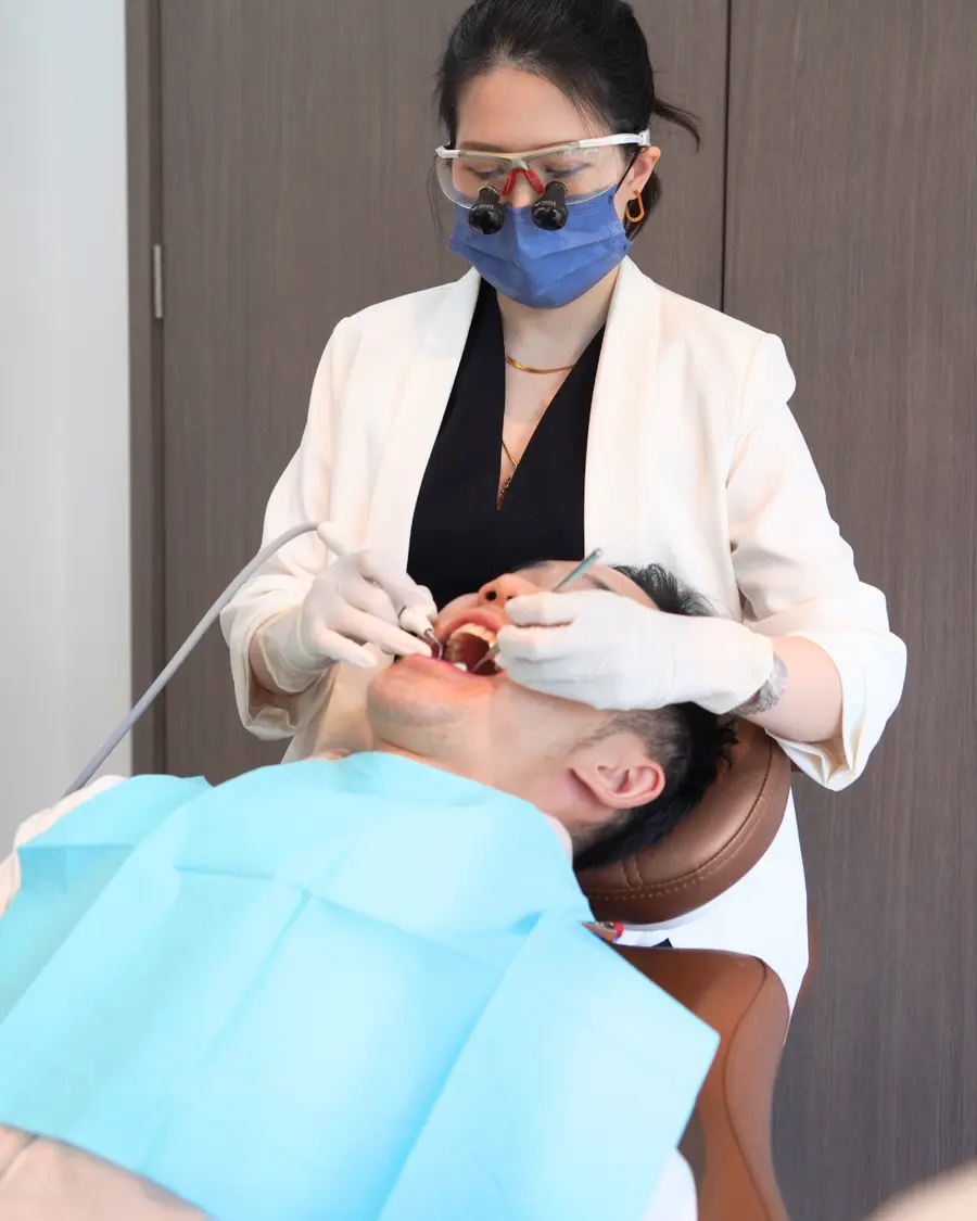 Dentist wearing loupes and a mask working in the treatment room
