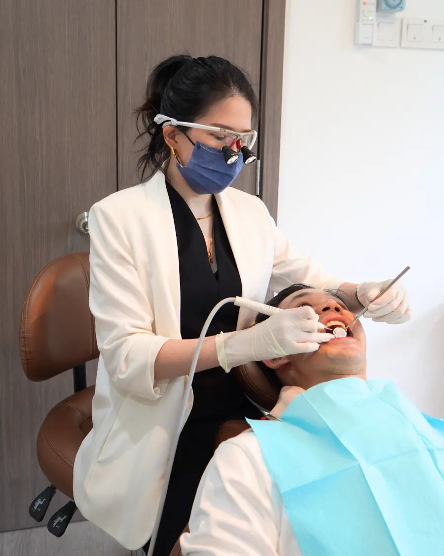 Dentist wearing magnifying loupes working at the dental chair in V Dental Clinic